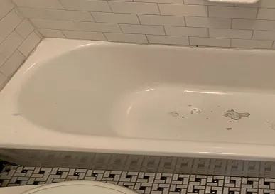 Outdated bathtub showing yellowing and surface damage before reglazing